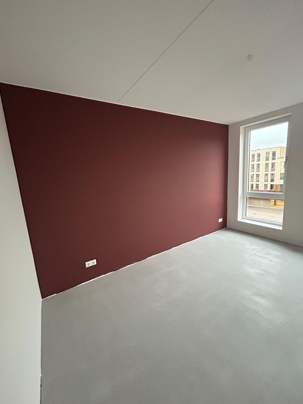 Woonkamer met warme wijnrode accentmuur